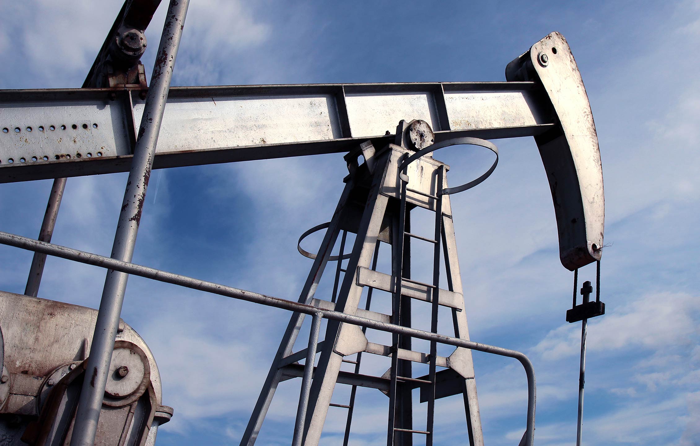 silver pumpjack in crude oil field mine