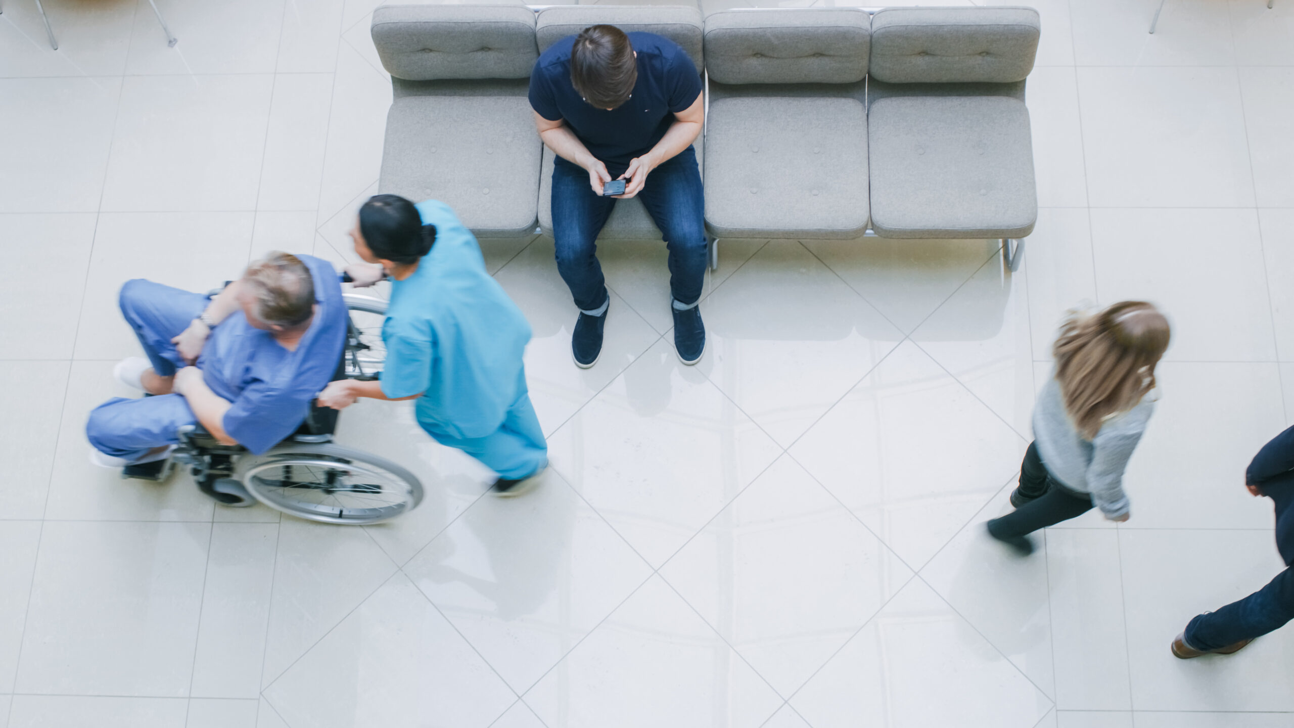 Modern medical waiting room with patients and a wheelchair, representing accessible health care services