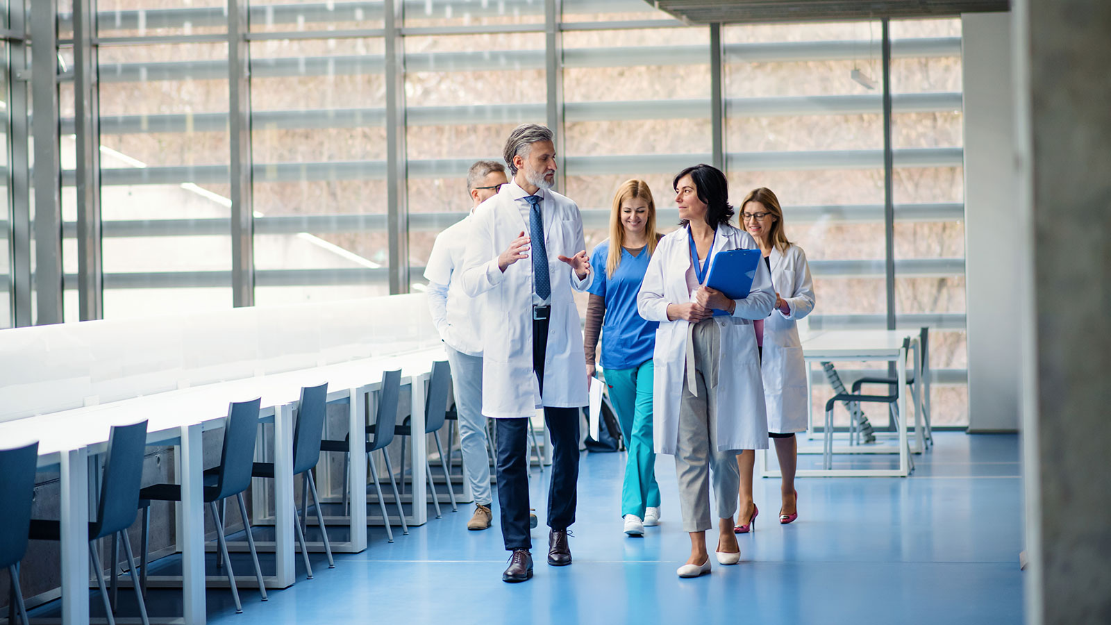 Group of doctors walking in corridor on medical conference.