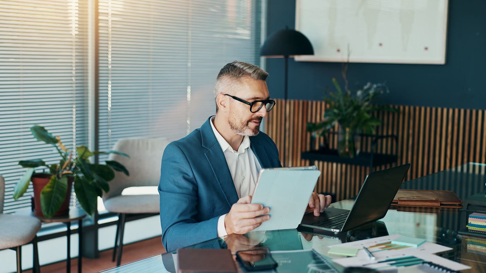 Tablet, laptop and reading with business man in office