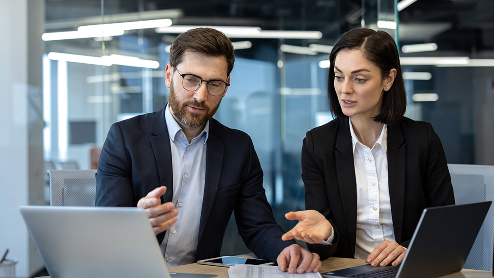 Two business professionals engage in discussion during a meeting