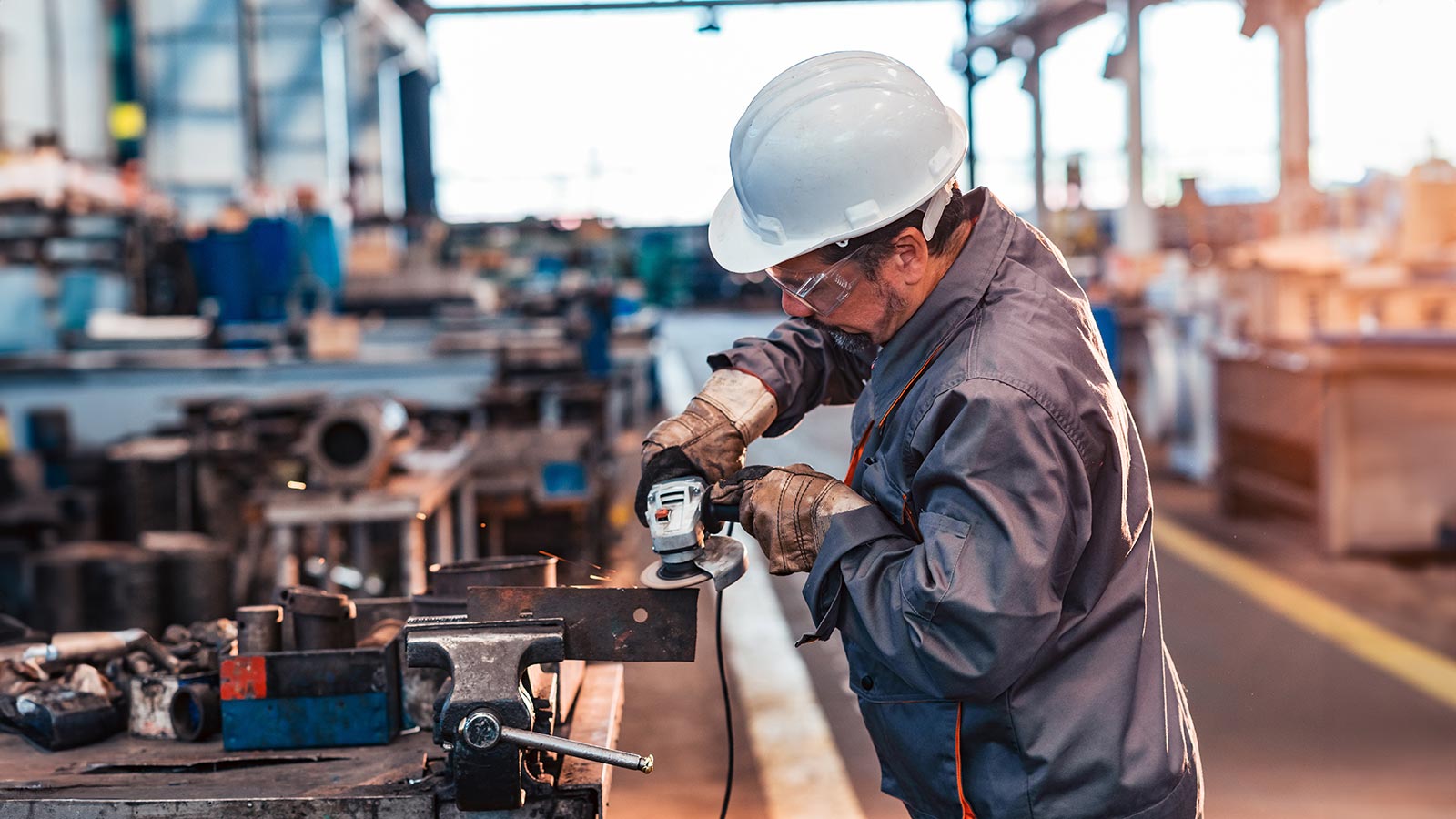Worker cutting metal at the factory