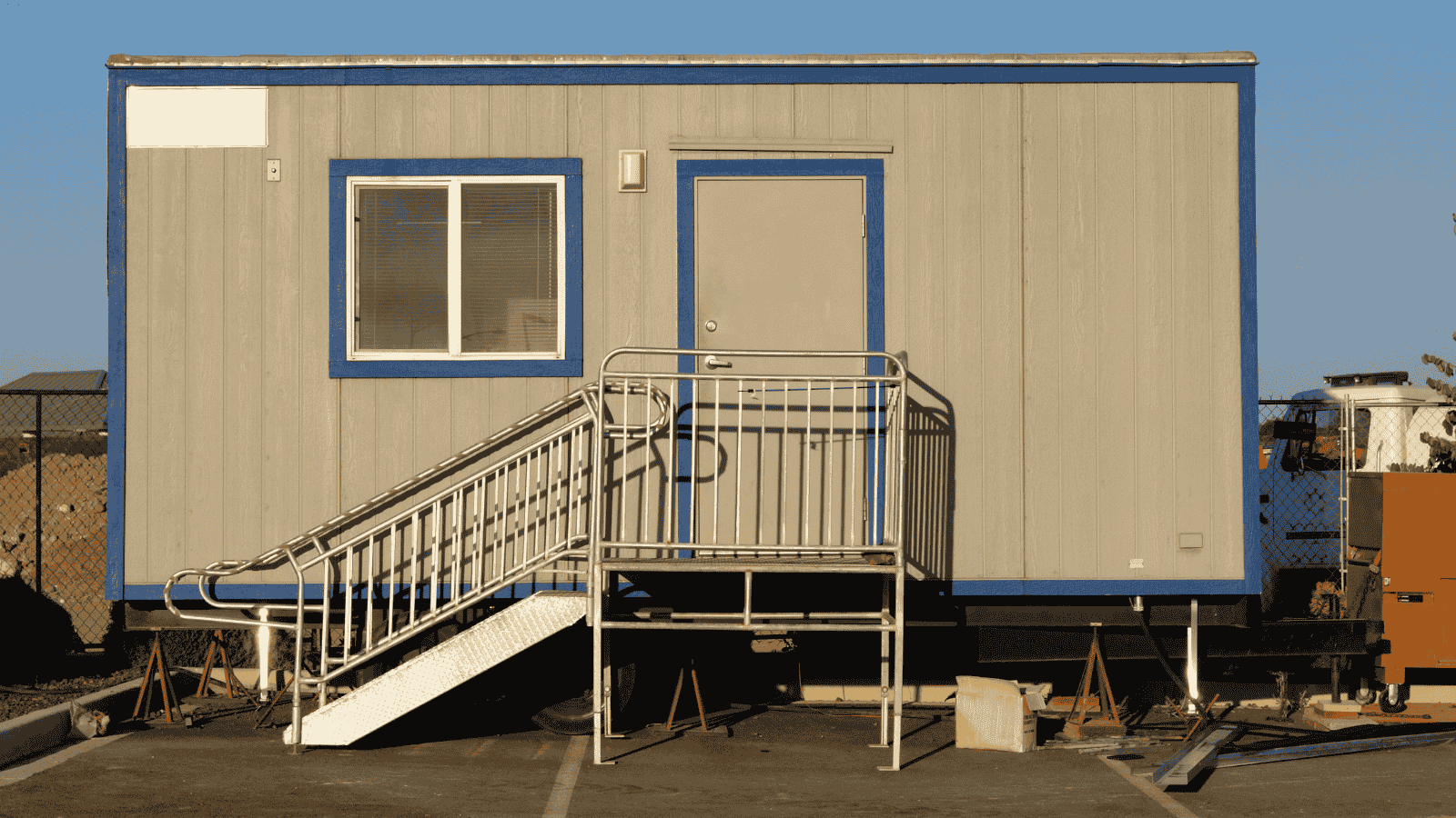 Mobile Construction Office Sitting in a Parking Lot with Stairs Leading up to it